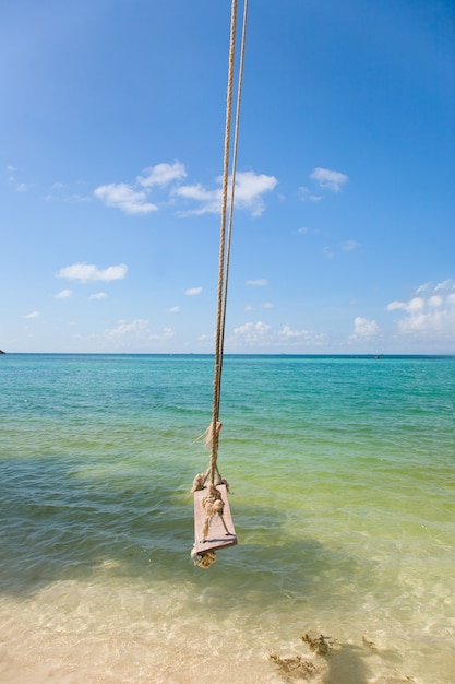 Spiaggia tropicale con la vecchia altalena legata all'albero