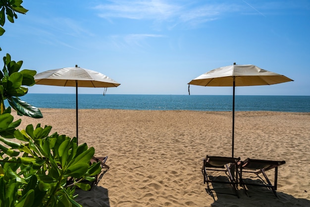 Spiaggia tropicale con ombrellone sotto le palme al sole, vacanze