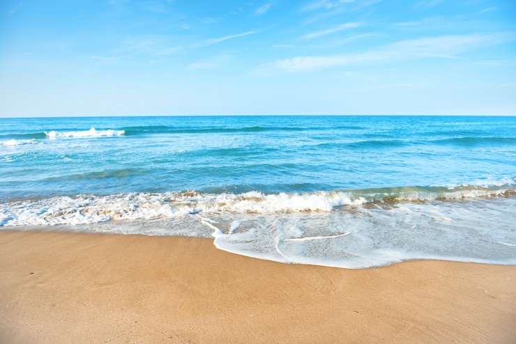 Foto spiaggia tropicale con onde di sabbia e mare sullo sfondo