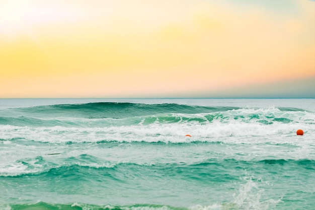 Spiaggia tropicale con orizzonte sfocato al tramonto sullo sfondo dell'acqua scintillante dell'oceano Paesaggio marino naturale