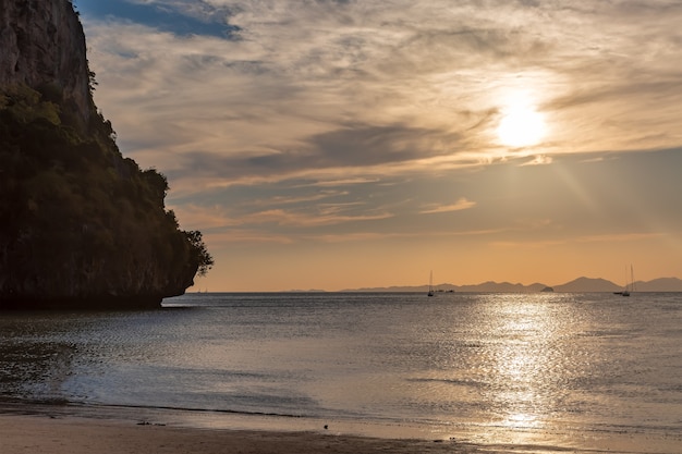 Spiaggia tropicale sabbiosa vuota sul tramonto Montagna a sinistra e su sfondi Colori dorati