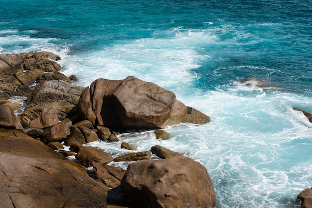 Spiaggia ventosa delle Seychelles con pietre e onde