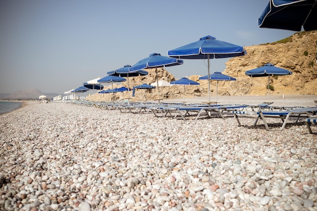 Spiaggia vuota con ombrelloni e lettini a fuoco selettivola bassa stagionevacanze estive e covidbeach w