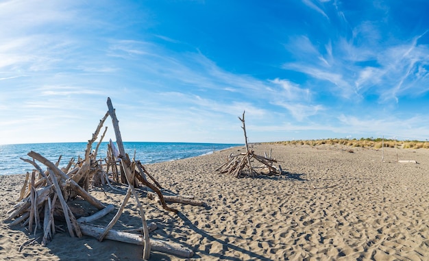 Spiaggia vuota nella riserva naturale della Maremma Toscana Italia Baia di sabbia nel parco naturale costa spettacolare promontorio roccioso e pineta mare mediterraneo blu sventolando l'acqua