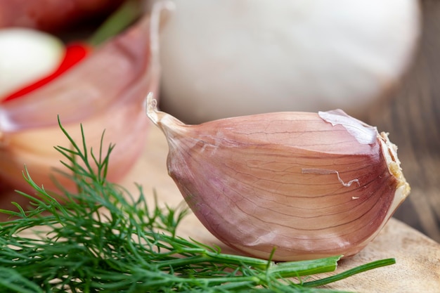 Spicchi d'aglio divisi in più parti su un tagliere La spezia all'aglio viene utilizzata per cucinare vari piatti