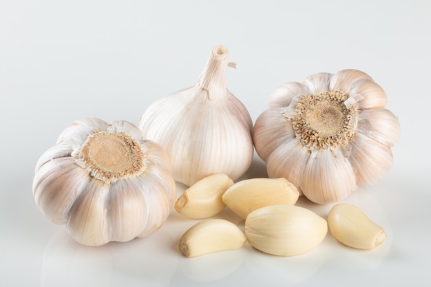 Spicchi d'aglio e bulbo isolato su sfondo bianco..