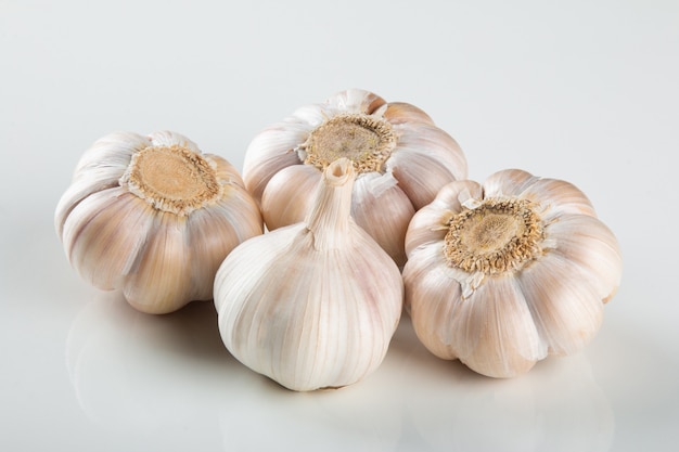 Spicchi d'aglio e bulbo isolato su sfondo bianco..