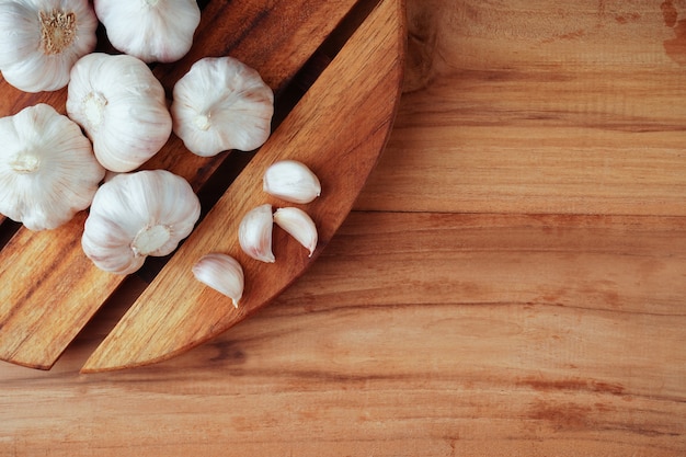 Spicchi d'aglio e lampadina sul tavolo di legno