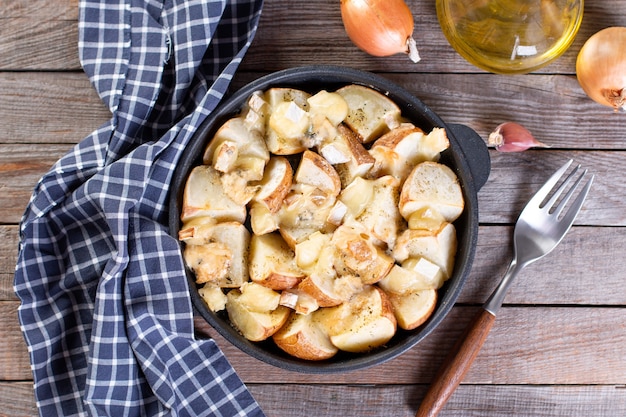 Spicchi di patate al forno con formaggio ed erbe aromatiche tavolo in legno - ortaggi biologici fatti in casa, spicchi di patate vegetariani vegani, spuntino