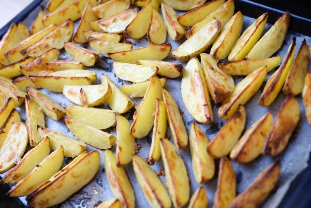 Spicchi di patate al forno fatti in casa su una teglia di pergamena