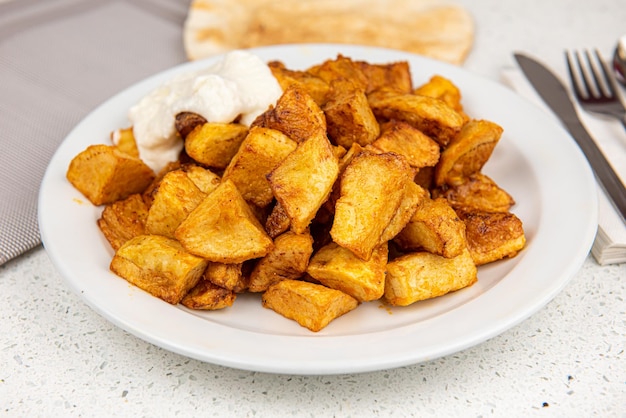 Spicchi di patate al forno su sfondo bianco da tavola