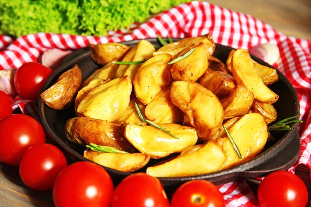 Spicchi di patate al forno sul primo piano del tovagliolo a scacchi