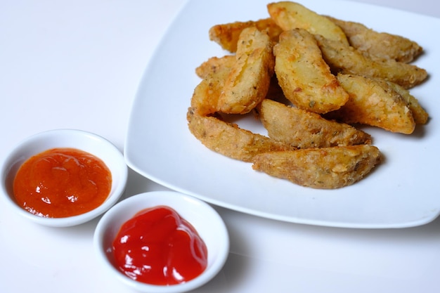 spicchi di patate e salsa di pomodoro e salsa di peperoncino. gli spicchi di patate sono un comune cibo da bar, fast food.