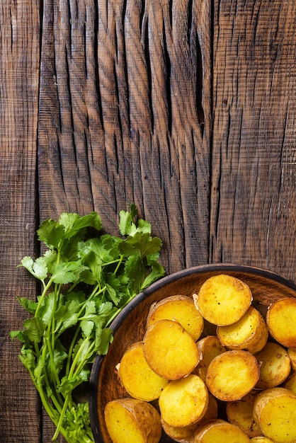 Spicchi di patate fritte su uno sfondo di legno scuro