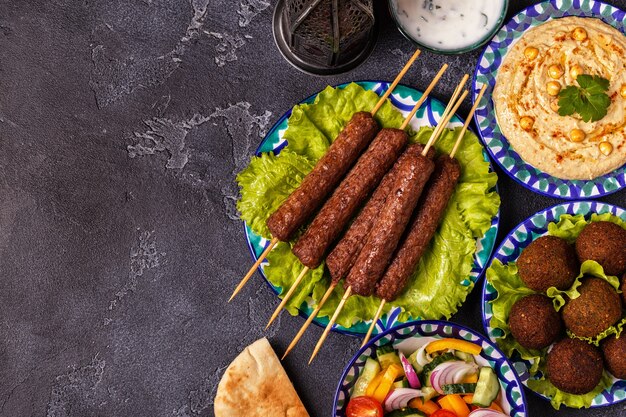 Spiedini classici, falafel e hummus nei piatti