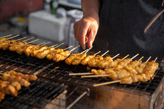 spiedini con carne satay sono alla griglia. cibo di strada asiatico