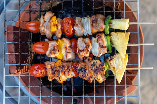 Spiedini con pezzi di barbecue verde peperone rosso pomodoro e carne per la vendita nel mercato di strada Thailandia primo piano