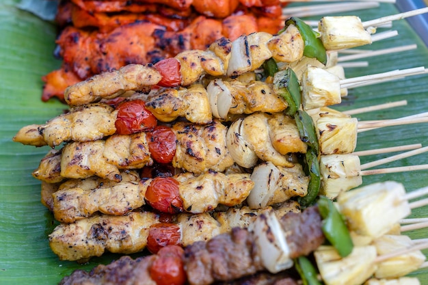 Spiedini con pezzi di barbecue verde peperone rosso pomodoro e carne per la vendita nel mercato di strada Thailandia primo piano