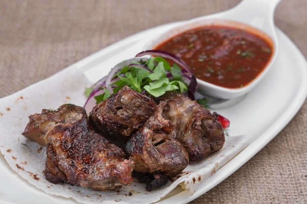 Spiedini di agnello alla griglia su un piatto bianco