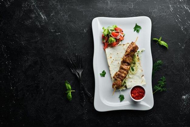 Spiedini di carne alla griglia con pita e verdure Spiedini di carne Piatti cibo Vista dall'alto Spazio libero per il testo