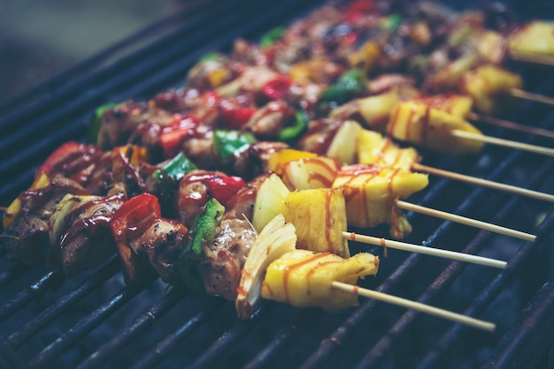 Spiedini di carne alla griglia e verdure barbecue sullo sfondo nero