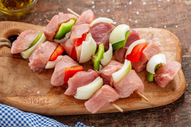 Spiedini di carne cruda appetitosi gustosi su fondo d'epoca in legno. Avvicinamento