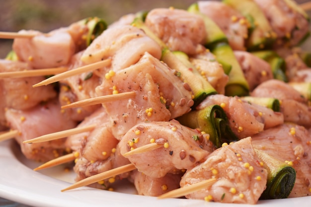 Spiedini di carne di pollo marinati crudi.