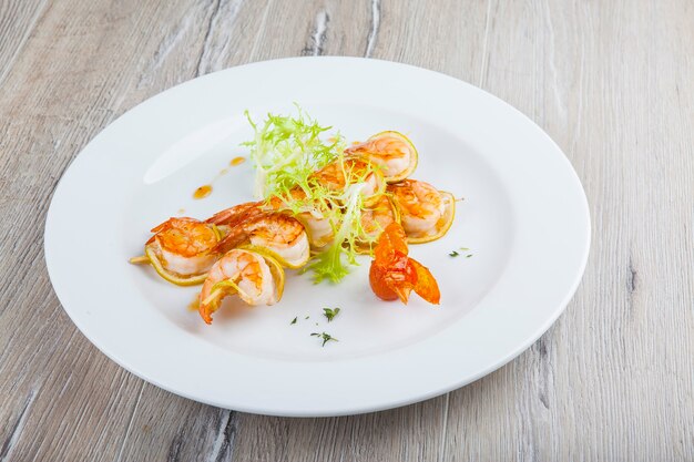 spiedini di gamberi fritti su un piatto bianco