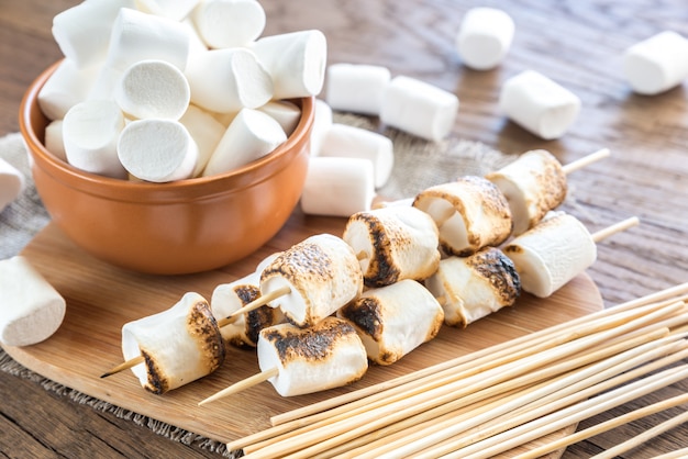 Spiedini di marshmallow sulla tavola di legno