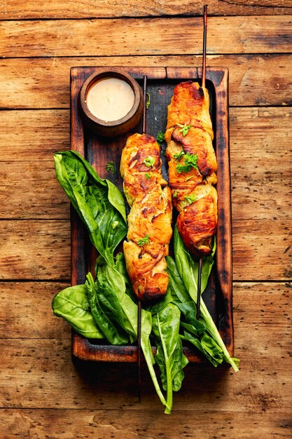 Spiedini di pollo carne alla griglia su fondo di legno