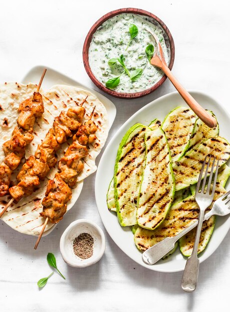 Spiedini di pollo tortillas di zucchine grigliate e salsa tzadziki delizioso pranzo in stile greco