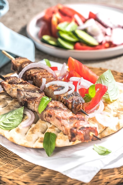 Spiedini di souvlaki di maiale su spiedini con insalata e tzatziki fresco fatto in casa