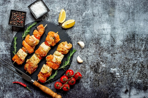 Spiedini su sfondo nero con limoni e aglio