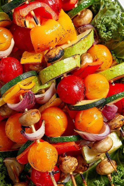 Spiedini vegetariani con erbe secche su spiedini di legno di zucchine pomodoro cipolla funghi su un piatto