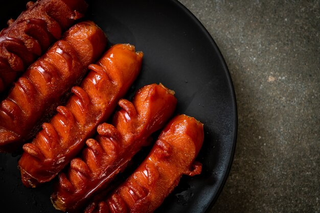 spiedino di salsiccia fritta su piastra nera