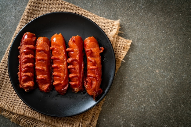 spiedino di salsiccia fritta su piastra nera