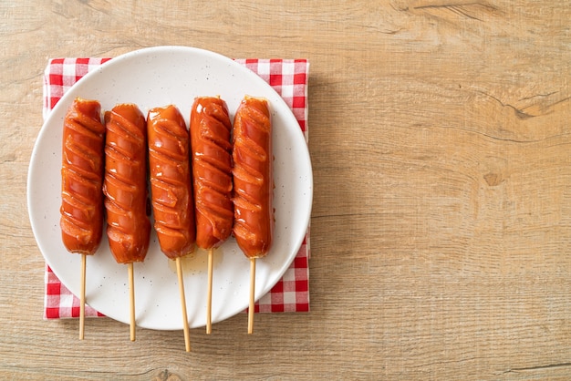 spiedino di salsiccia fritta su piatto bianco