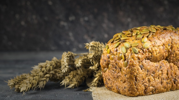 Spighe di grano accanto alla farina di pane su un tavolo di legno