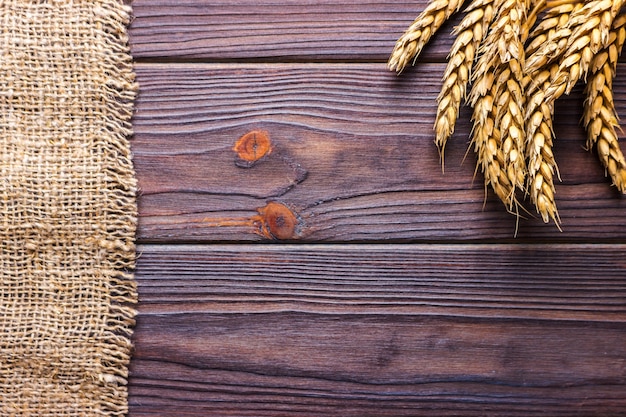 Spighe di grano e stoffa su fondo in legno