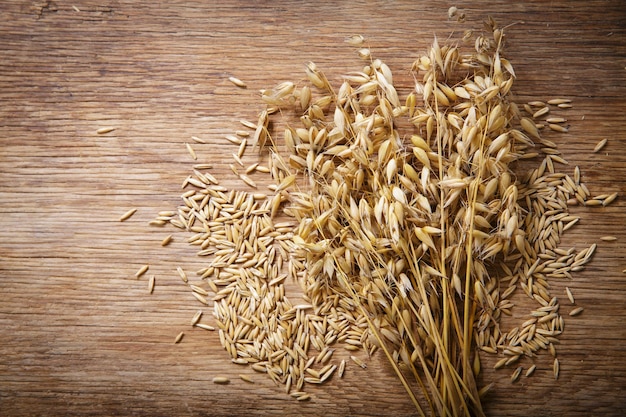 Spighe mature di avena e cereali su sfondo di legno