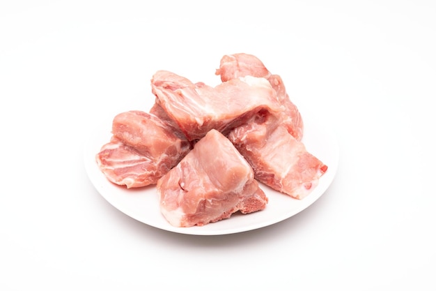 Spina dorsale di maiale cruda in piatto bianco isolato su bianco