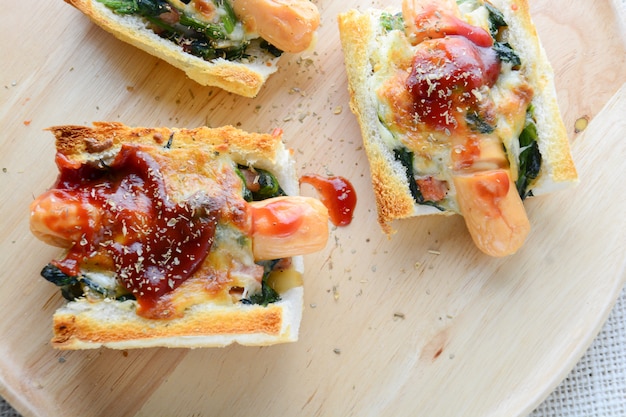 Spinaci al forno con formaggio, salsiccia su baguette, pane francese