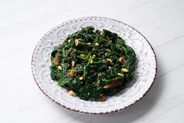 Spinaci cotti in padella con uvetta pinoli e aglio