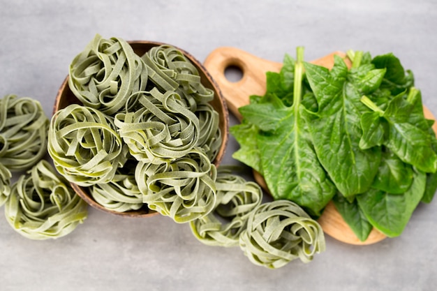 Spinaci freschi con pasta verde su un grigio