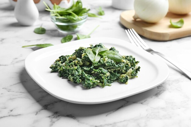 Spinaci saporiti sul tavolo di marmo bianco Cibo sano