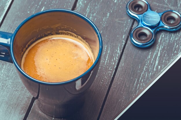 Spinner, telefono e caffè sul tavolo di legno