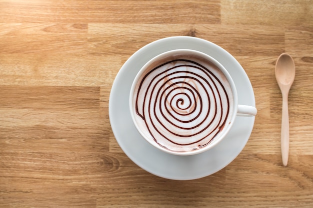 Spirale di cioccolata calda sul tavolo di legno con spazio per la formulazione