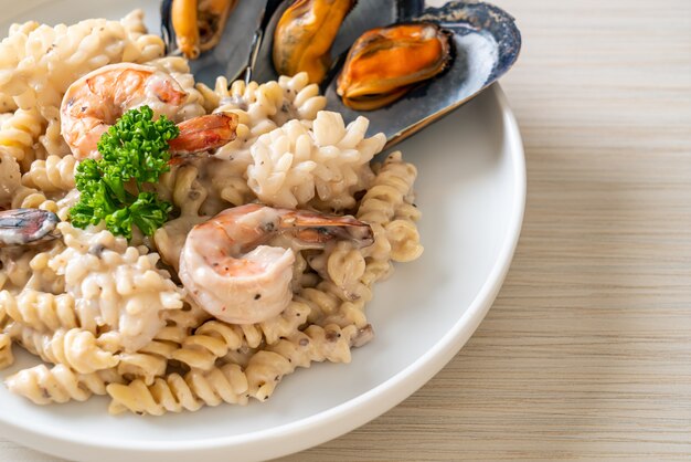 spirale pasta funghi salsa di panna con frutti di mare. Stile di cibo italiano