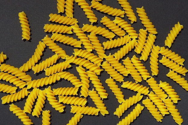 Spirali di pasta cruda su sfondo nero Sfondo vista dall'alto