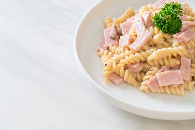 spirali o spirale di pasta con salsa di funghi e prosciutto. Stile di cibo italiano